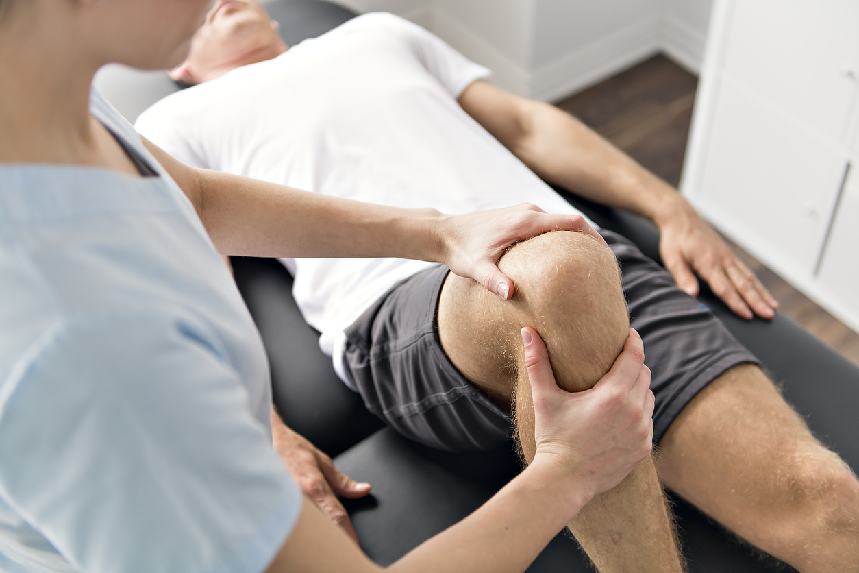 Physiotherapist working on client's knee